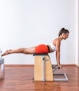 Side View of a Woman in Activewear Doing Pilates Reformer Exercise