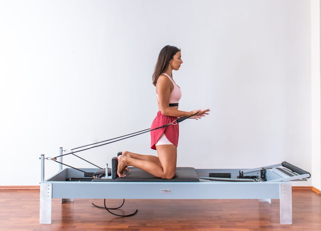 Side View of a Woman in Activewear Doing Pilates Reformer Exercise · Free  Stock Photo