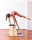 A Woman in Activewear Doing Pilates Reformer Exercise