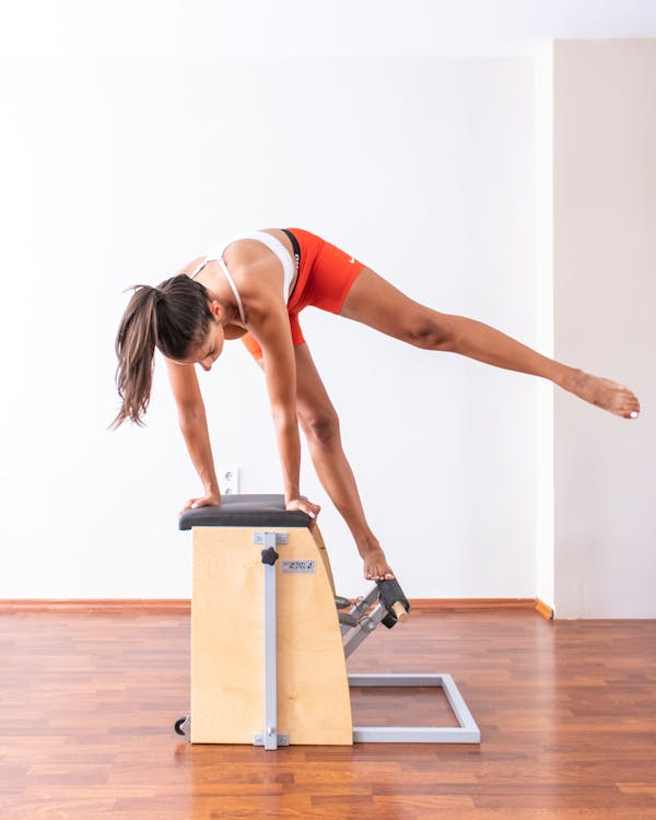 A Woman in Activewear Doing Pilates Reformer Exercise · Free Stock Photo