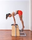 Side View of a Woman in Activewear Doing Pilates Reformer Exercise