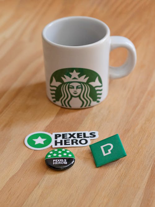 A Starbucks Cup near the Pexels Pin and Sticker