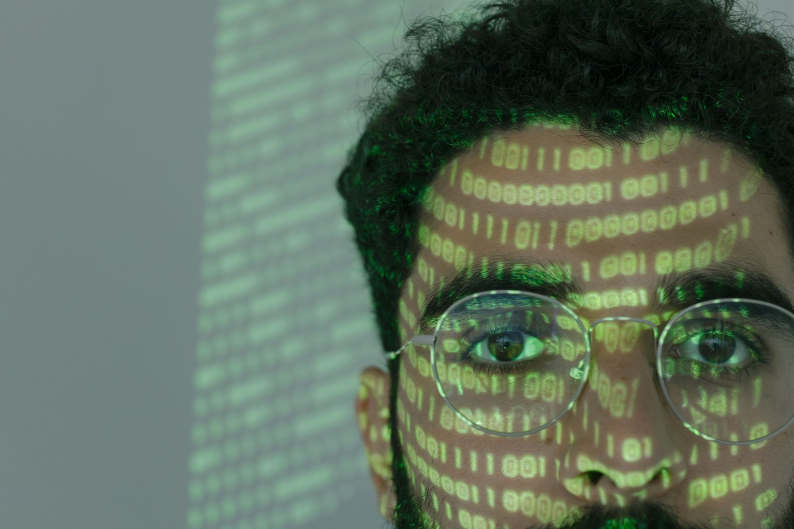 Close-up of a person with binary code projected, symbolising the structured EXIF directory inside every photo file