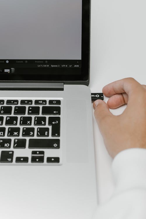 Free Hand Putting a USB Flash Drive in a Laptop Stock Photo