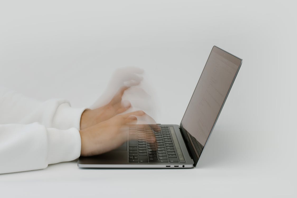 Free Hands Typing on a Laptop Keyboard Stock Photo