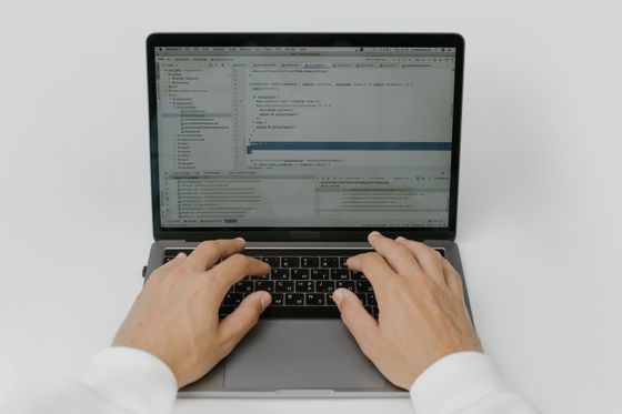 Overhead view of hands on a laptop at a white desk