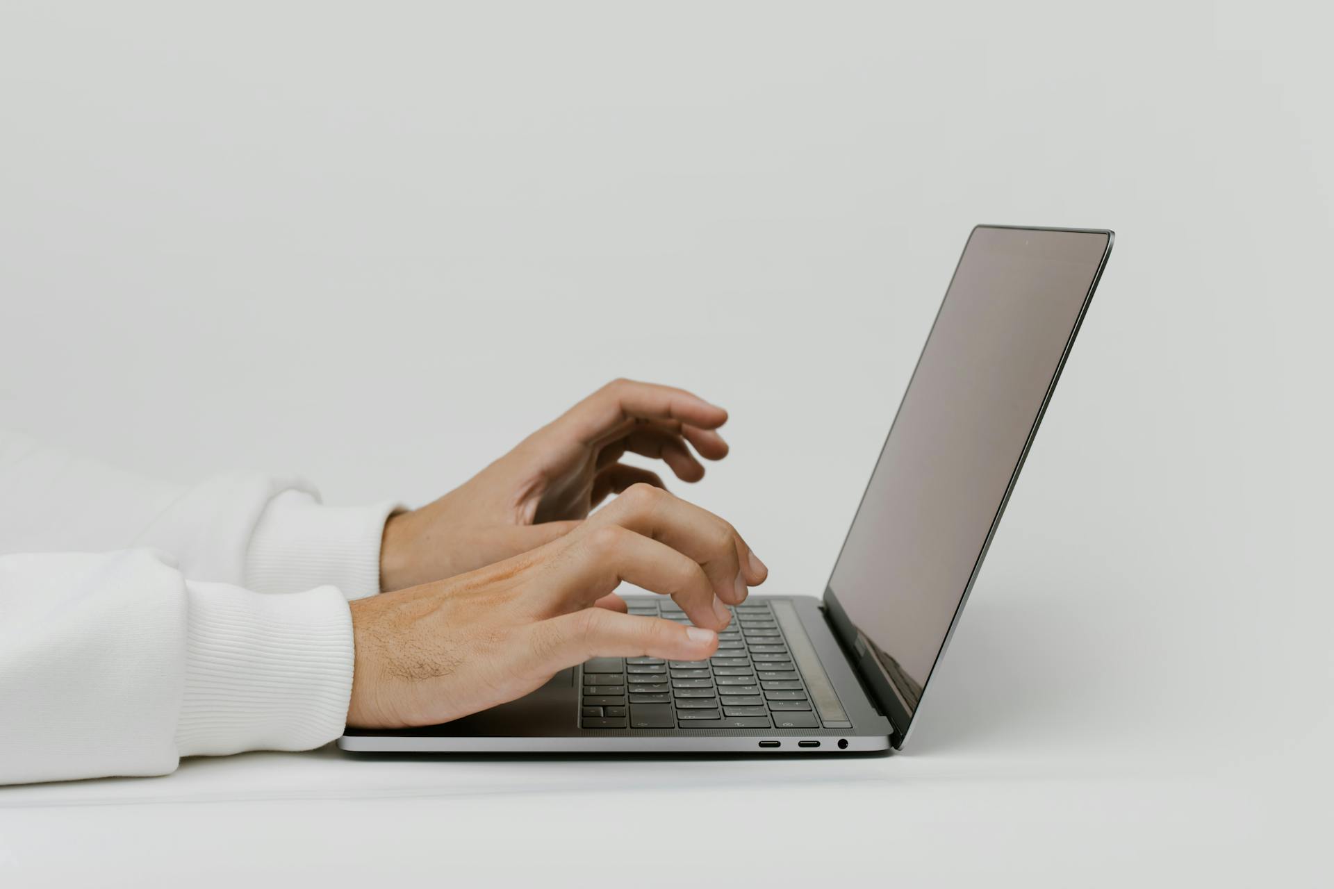 Close-up of hands typing on a laptop with ample copy space for text. Ideal for work and technology themes.