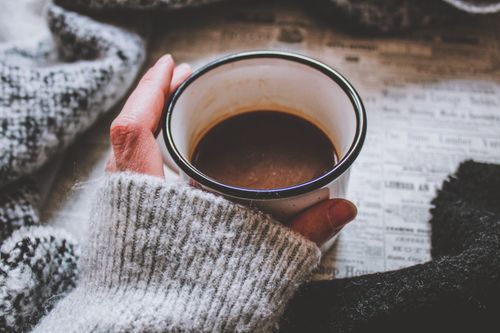 Free A close-up of a warm cup of coffee held in hand, creating a cozy, calming atmosphere. Stock Photo