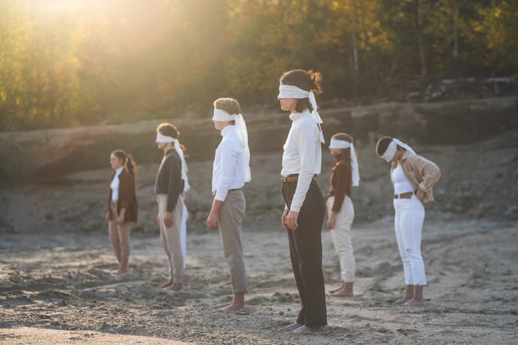 Blindfolded People Standing On Sand