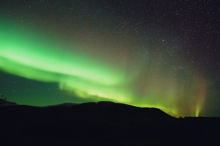 Bright Green Northern Lights Above Mountain At Night