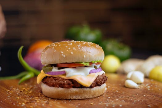 Mouth-watering cheeseburger with fresh ingredients on a wooden board, perfect for food photography.