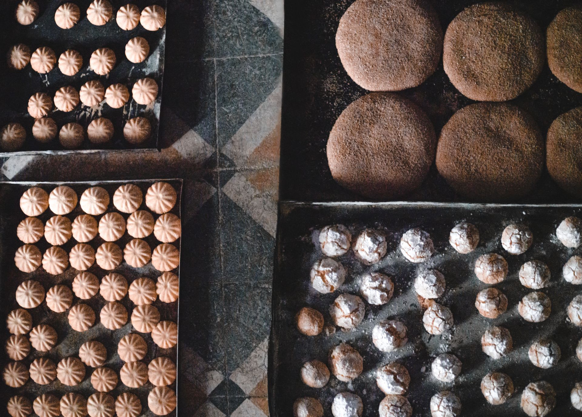 Aerial view of assorted fresh Moroccan pastries and cookies on trays, showcasing traditional bakery delights.