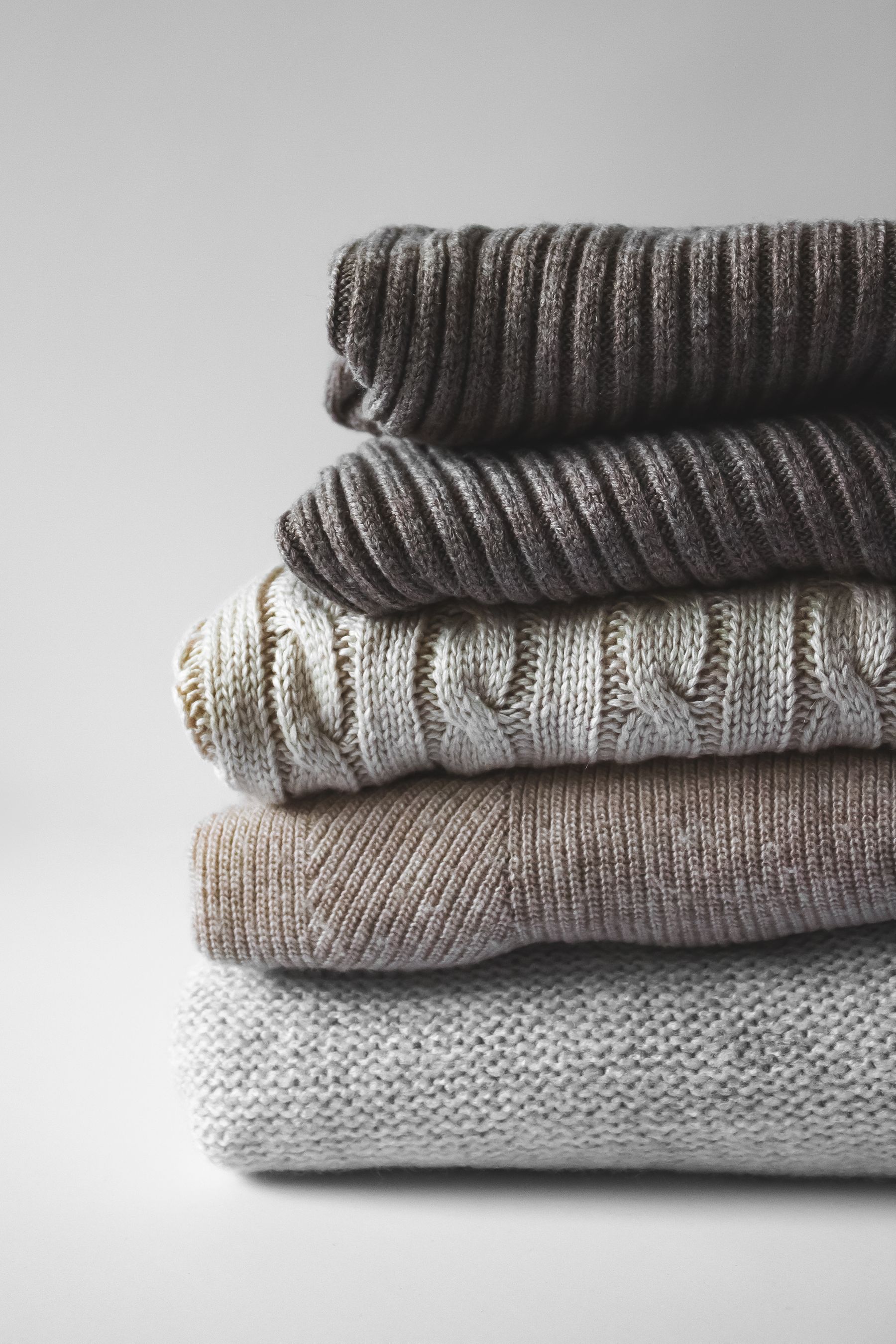 A stack of finished knitwear seen from above, greys slightly mismatched