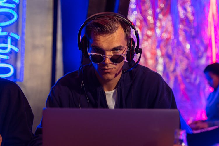 A Man In Sunglasses Using A Laptop