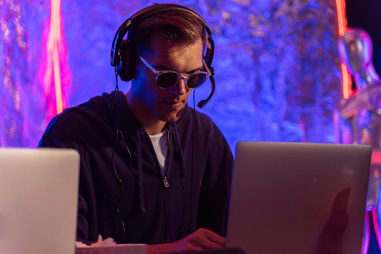 Man In Black Jacket Wearing Headphones Whole Working On A Laptop