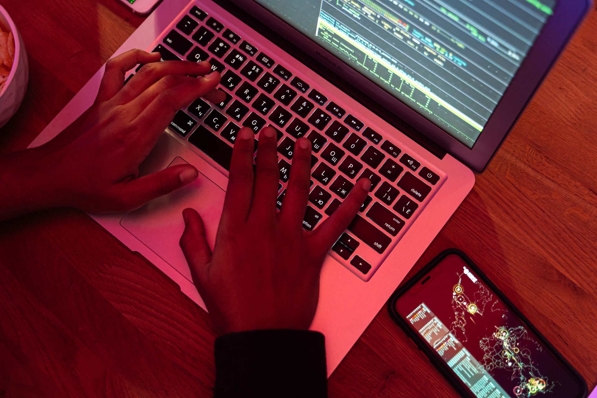 Un puesto de desarrollo entrada la noche, con teclado frente a una pantalla iluminada.