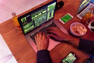Person Using Macbook Pro on Brown Wooden Table