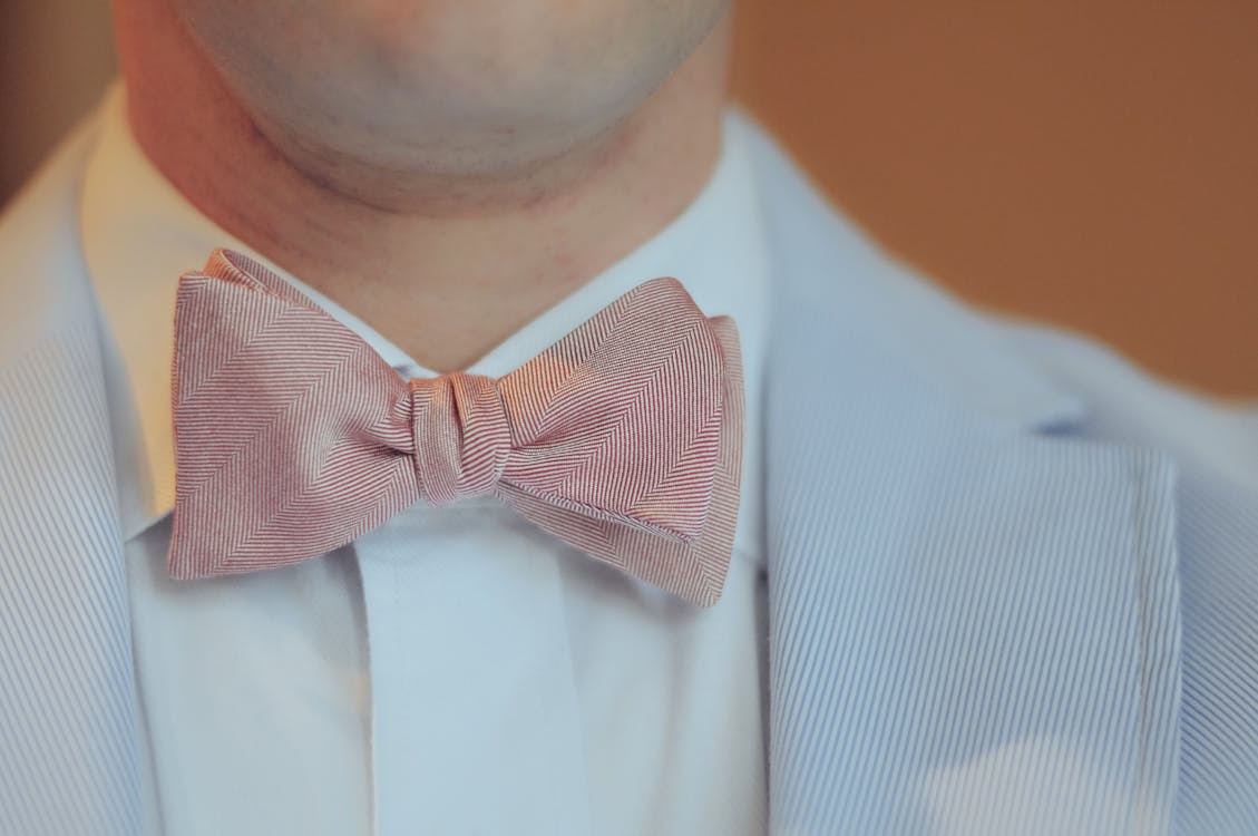Free Close-up Photography of Person Wearing Pink Bow-tie and Gray Notched Lapel Suit Stock Photo