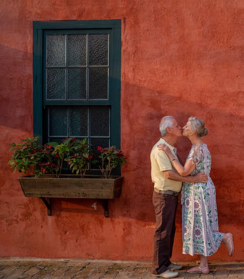 남자와여자가 붉은 벽돌 벽 앞에 서있는