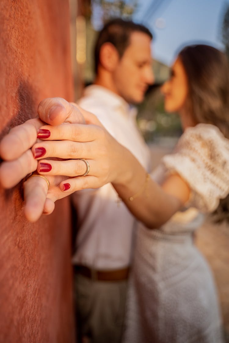 Anonymous Newlywed Couple Embracing Near Wall On Street