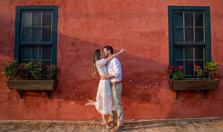 Unrecognizable Stylish Couple Kissing On Pavement Near Old Building