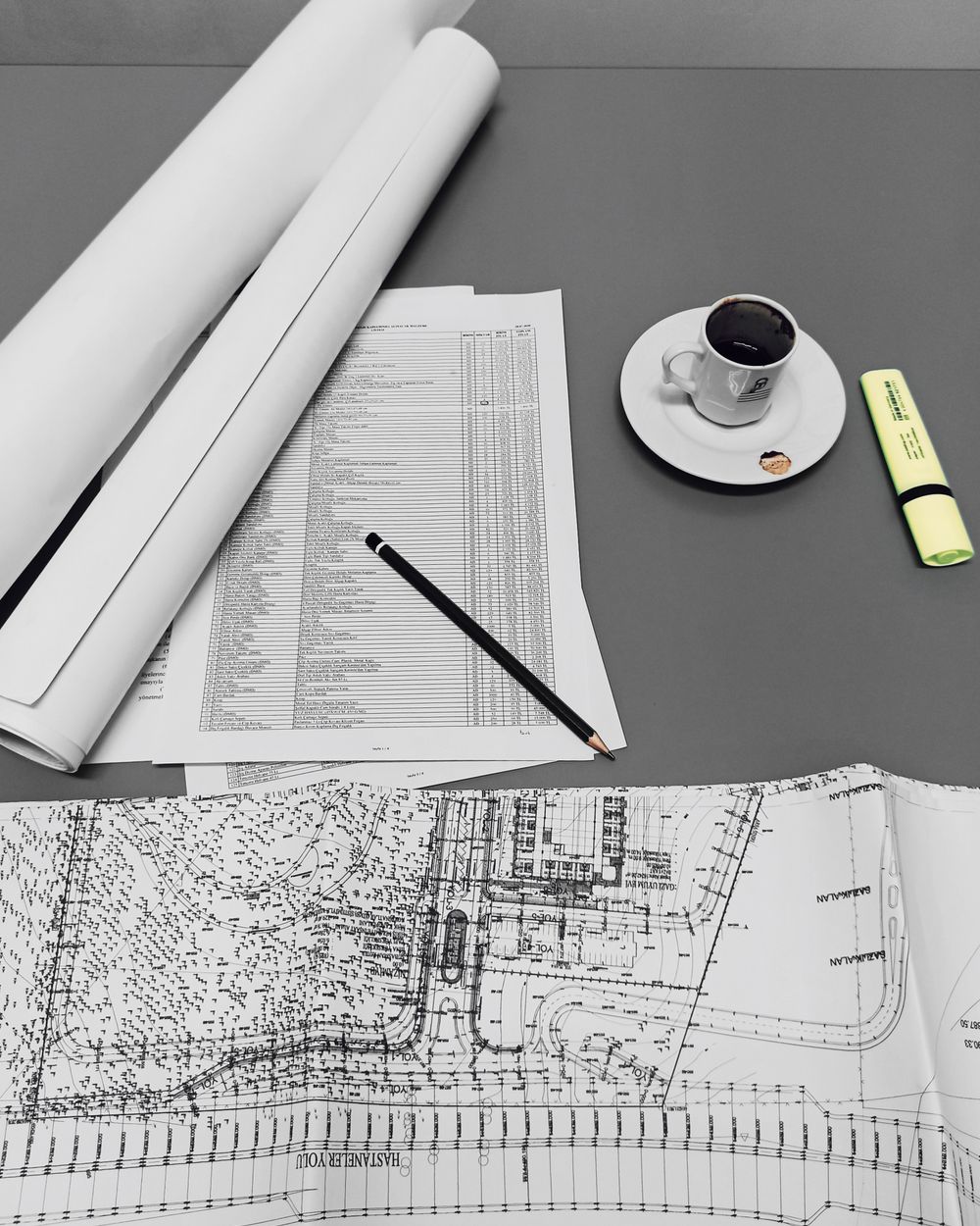 Bill of quantities printout with drawings, a pencil and coffee