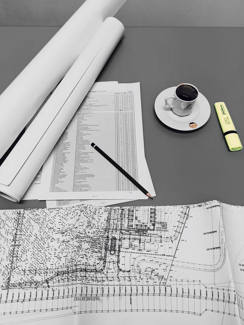 Blueprints and drafts with stationery on a desk