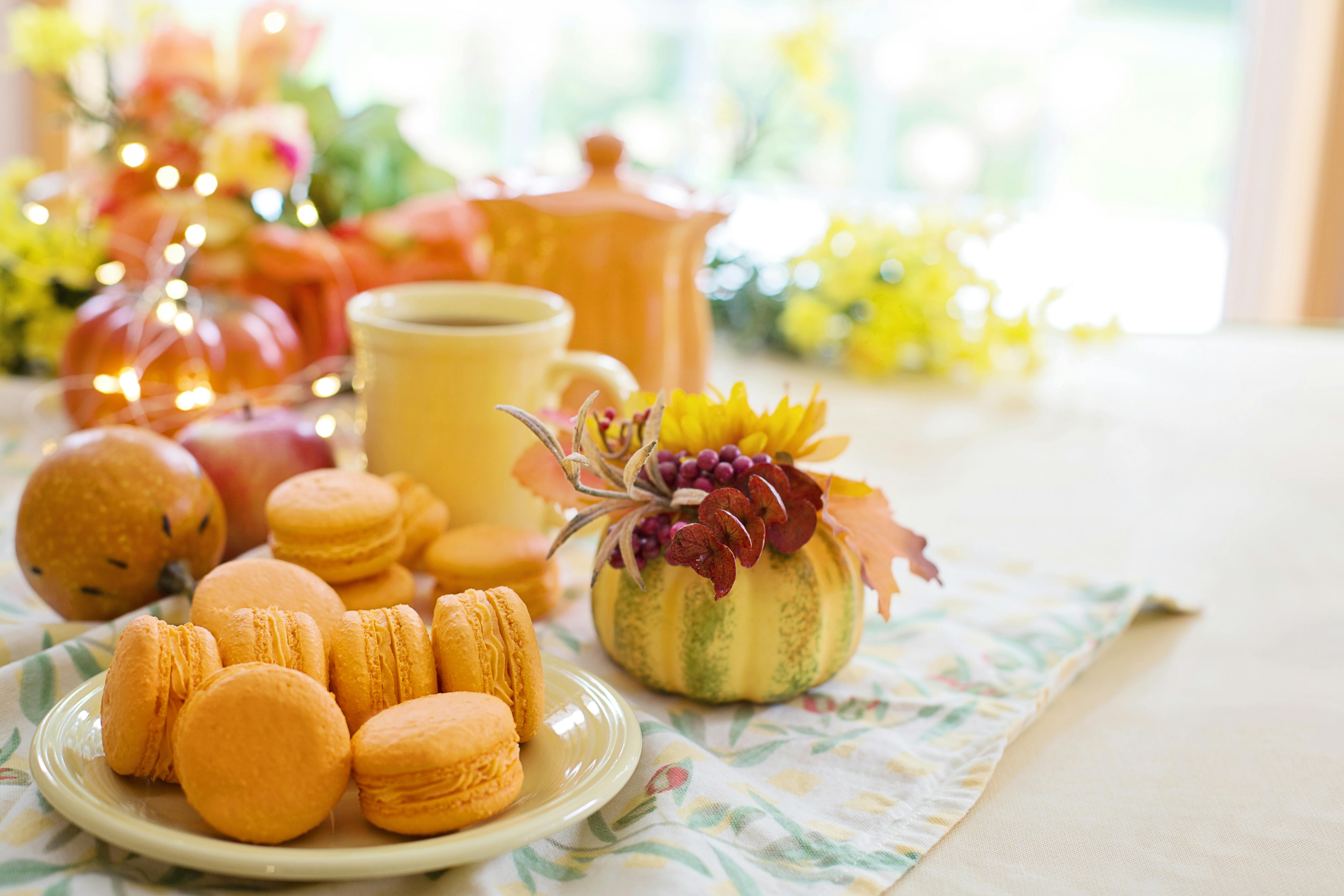 A charming autumn-themed table with macarons and seasonal decor, perfect for festive indulgence.