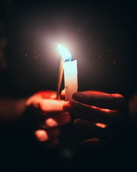 特写镜头聚焦于手握点燃的蜡烛，传递出温暖宁静的氛围，强调了光明与宁静