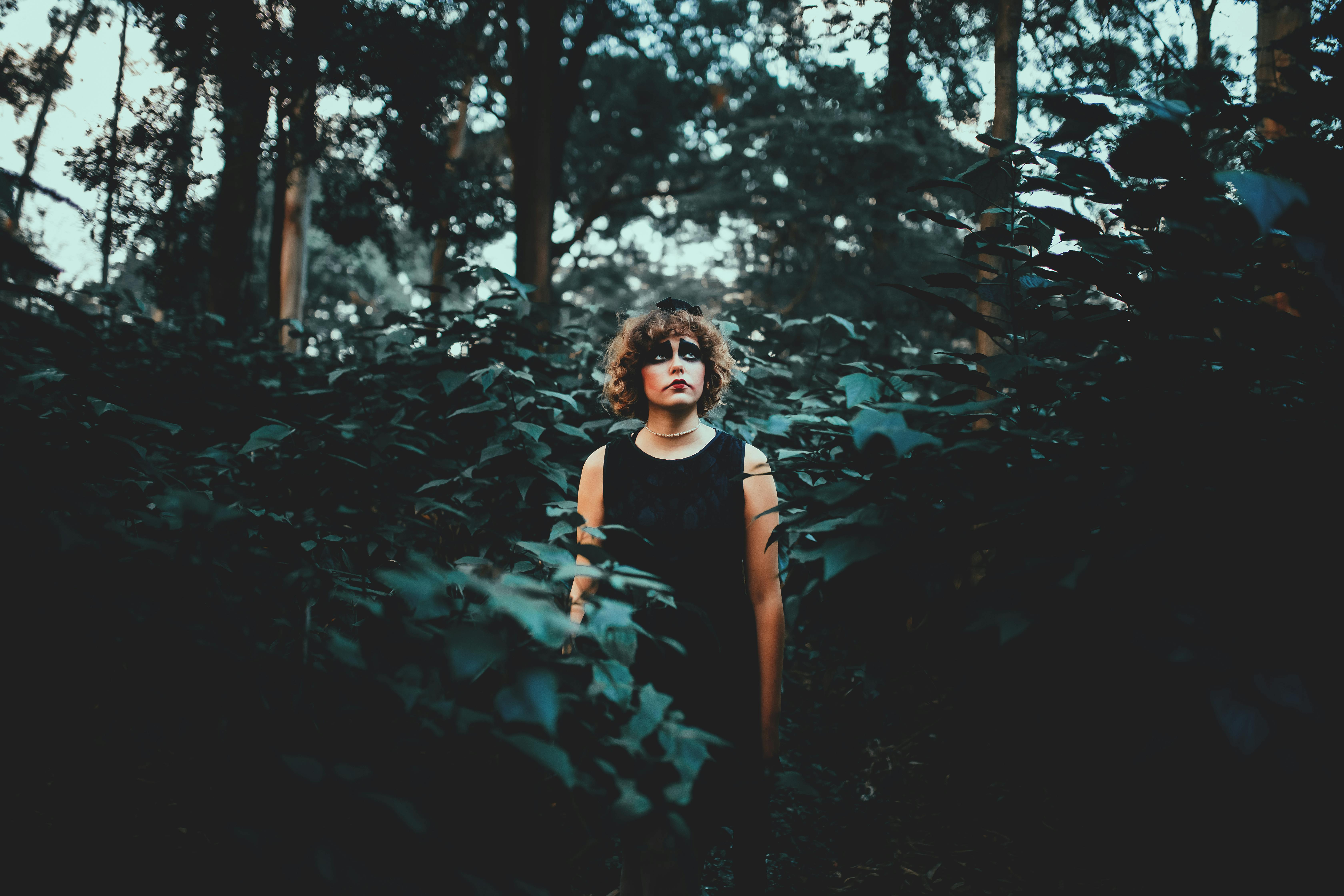 dreamy woman with terrible makeup in forest during halloween