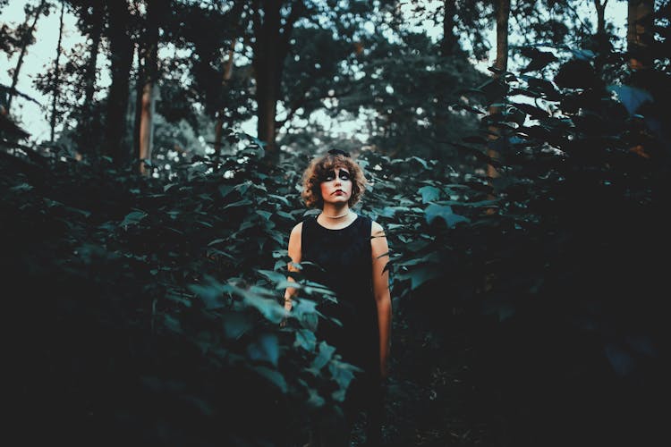 Dreamy Woman With Terrible Makeup In Forest During Halloween