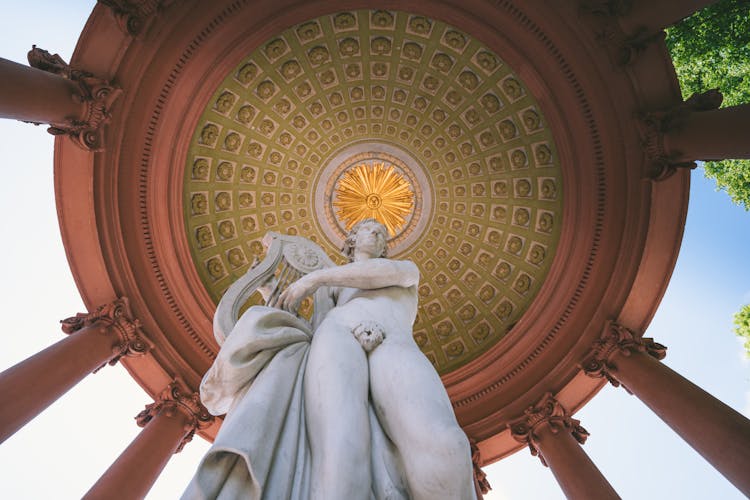 Ancient Statue Under Roof Of Classic Outdoor Gazebo