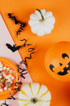 万圣节装饰品以橙色为背景，上面有南瓜和糖果