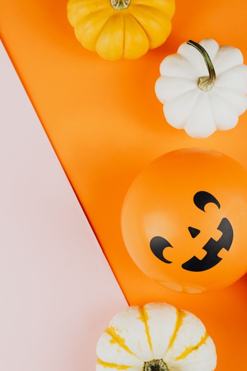 Free Halloween pumpkins and Jack O Lantern balloon on colorful background. Stock Photo