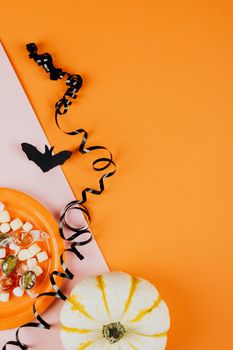 橙色背景下有糖果、南瓜和装饰品，这是万圣节主题