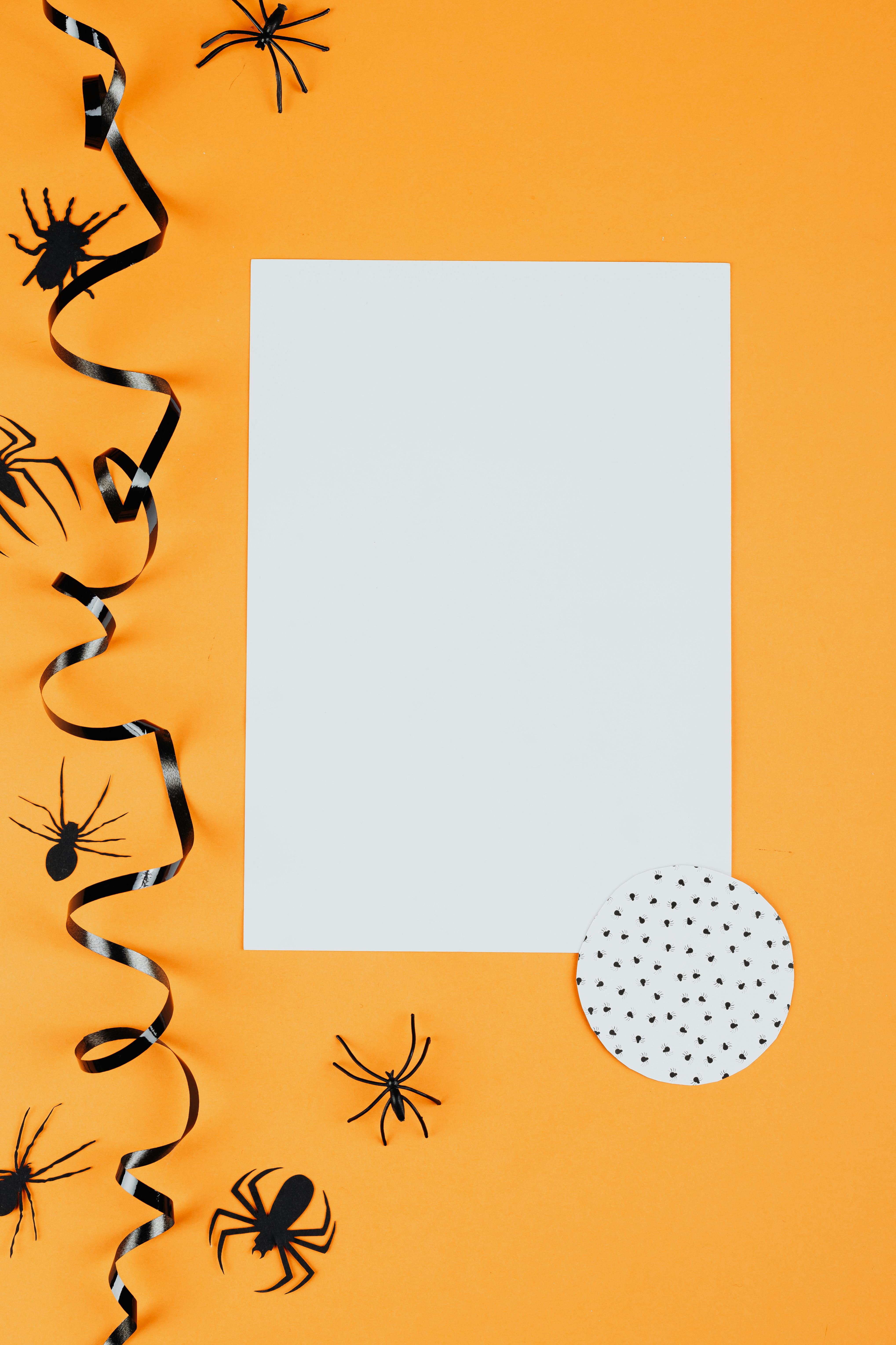 这款以万圣节为主题的纸质装饰，橙色背景上点缀着蜘蛛图案，非常适合节日设计