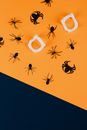 在橙色和黑色背景上，以格林为主题的蜘蛛和吸血鬼牙齿剪影