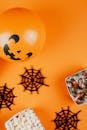 万圣节装饰和糖果平躺在一个生动的橙色背景上