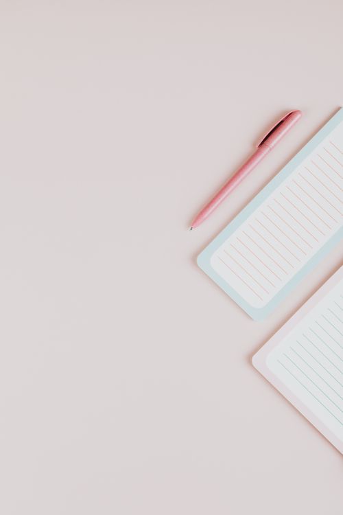Free Pink pen and lined notepad on a pastel surface, perfect for stationery themes. Stock Photo
