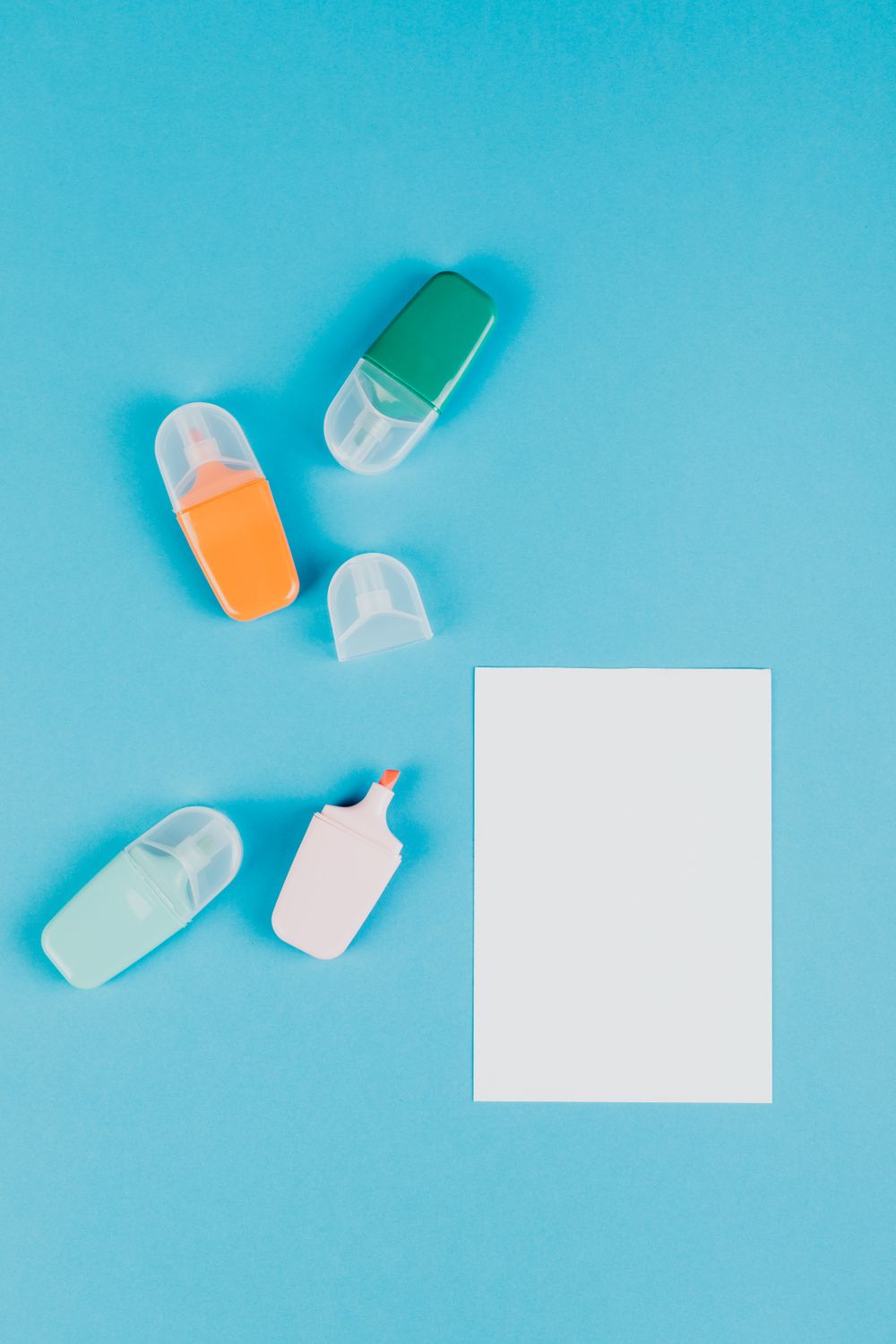 Highlighters and Paper against a Blue Background · Free Stock Photo