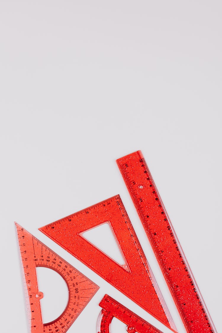 Red Rulers And Triangles On White Background