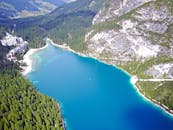 这张令人惊叹的航拍照片展现了意大利多洛米蒂山脉中，被针叶林环绕的布雷伊斯湖