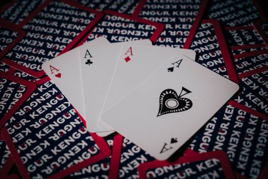 Close-up of a poker hand with four aces displaying custom back design. Perfect for themes of luck and gambling.