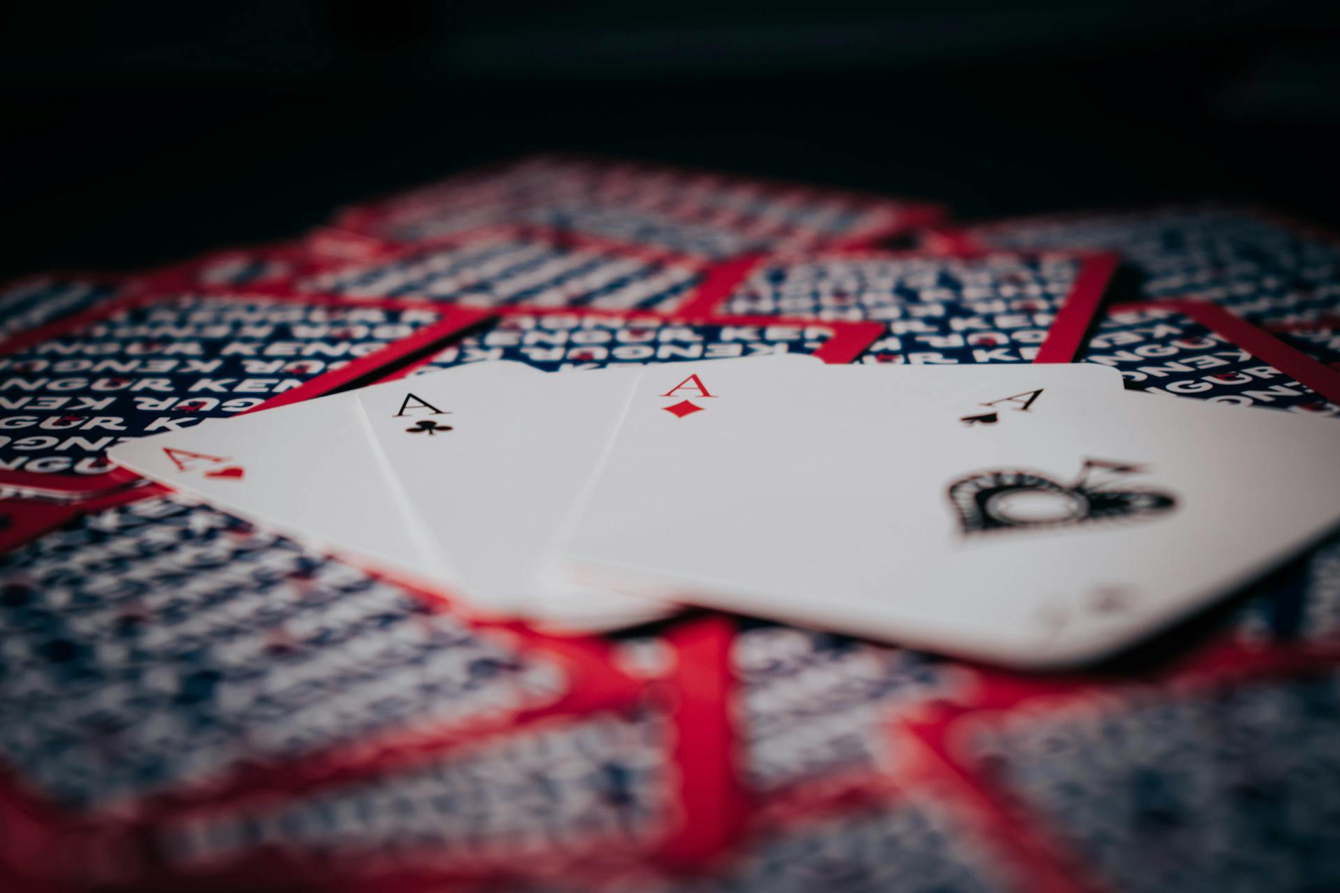 Focused view of four aces laid on a deck, symbolizing high stakes poker action.