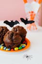 这款自制的巧克力纸杯蛋糕味道很棒，上面装饰着万圣节饰品和彩色糖果