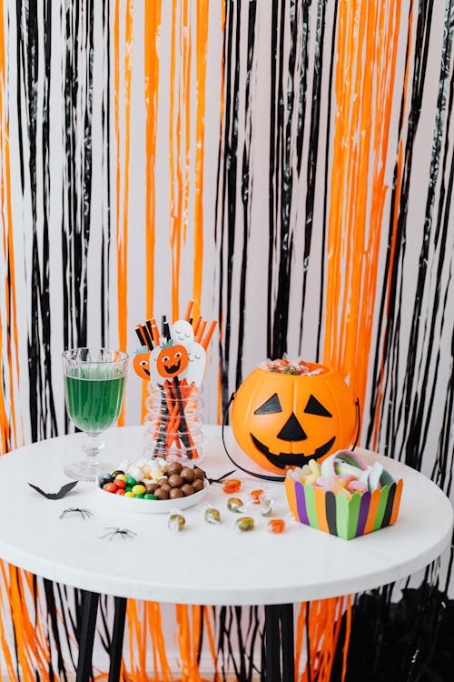 Orange Jack O' Lantern with Candies on a White Table