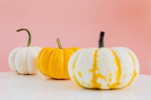 Yellow and White Pumpkins on a White Table