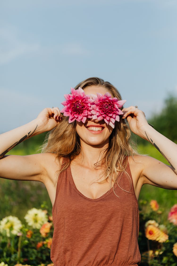 Smiling Woman Covering Eyes With Flowers