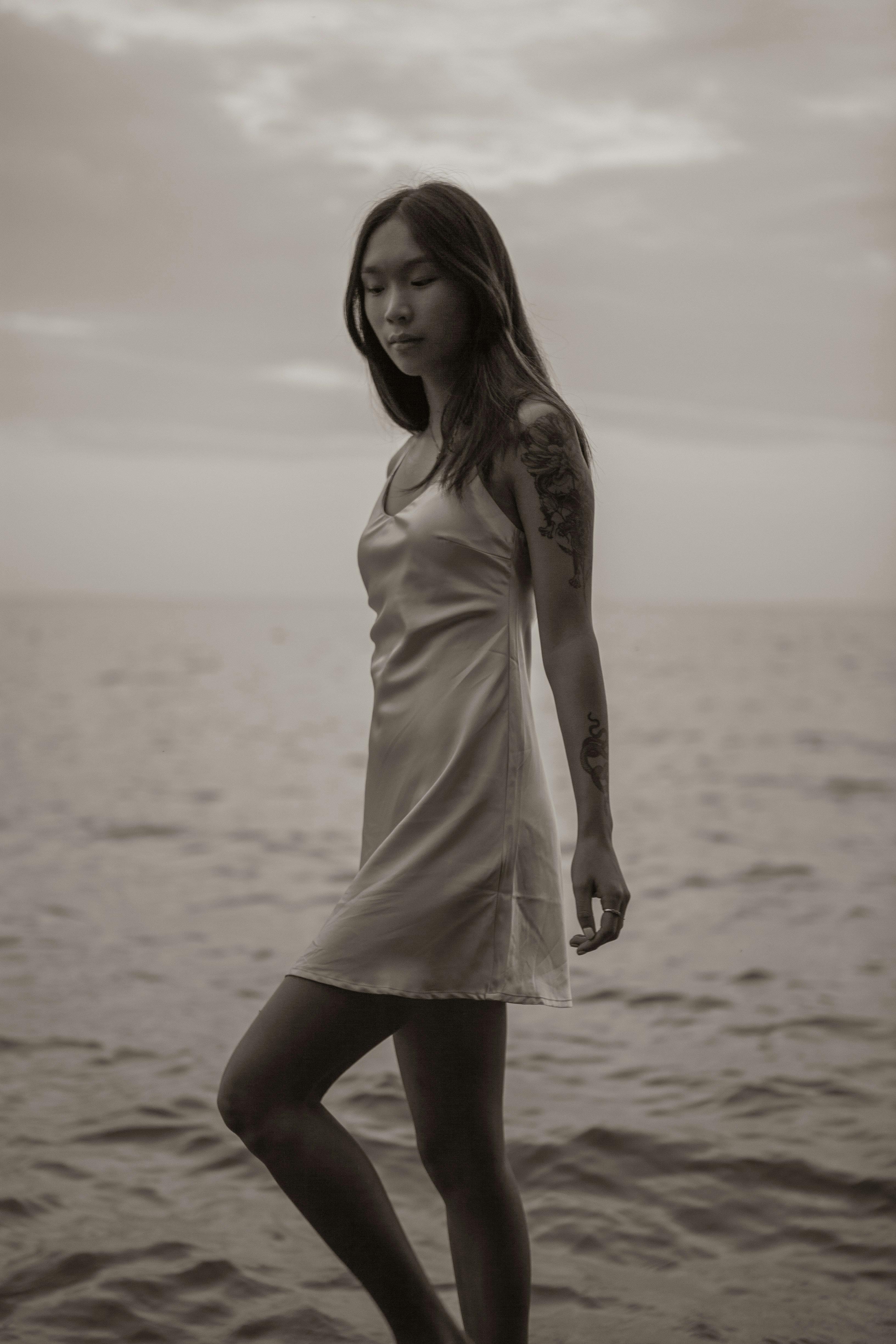 sensual young slim ethnic woman walking in sea water