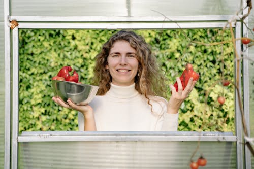 A Woman Holding Red Bell Peppers